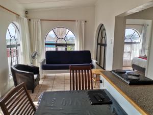 een woonkamer met een bank en een tafel bij Oom Piet Accommodation in Gansbaai