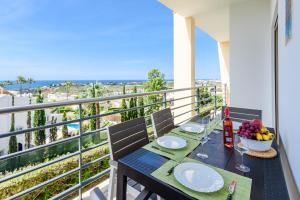 アルブフェイラにあるOcean view Apartment with sunbathing Terrace, 2 Swimming pools & Tennis courtのテーブル(ワイングラス付)、バルコニー(フルーツボウル付)
