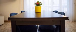 une table avec des chaises et un vase jaune avec des fleurs. dans l'établissement Domusvacanza Salento, à Santa Caterina