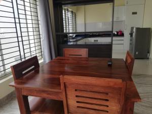 a wooden table and chairs in a kitchen at Castle JP Deluxe in Bangalore