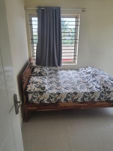 a bed sitting in a room with a window at Castle JP Deluxe in Bangalore
