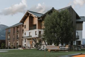 ein großes Gebäude mit einem Baum und einer Bank in der Unterkunft Thalers Mariandl in Schladming