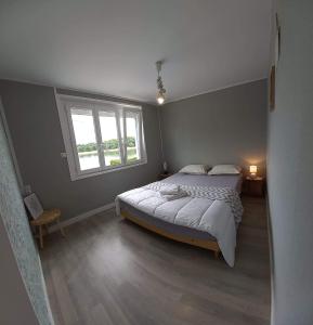 Un dormitorio con una cama grande y una ventana en Maison Mon p’tit bonheur, en Changey