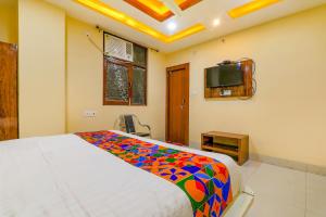 sypialnia z łóżkiem i telewizorem na ścianie w obiekcie FabExpress Shree Galaxy w mieście Kanpur