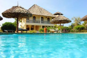 een resort met een zwembad met parasols bij Marula Park in Diani Beach