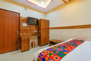 um quarto com uma cama com um cobertor colorido em FabExpress Shree Galaxy em Kanpur