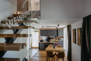 a dining room and kitchen with a spiral staircase in a house at Weinberg Chalets in Eisenberg an der Pinka