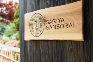 a sign on the side of a wooden building at Takamiya Ryokan Sagiya Sansorai in Kaminoyama