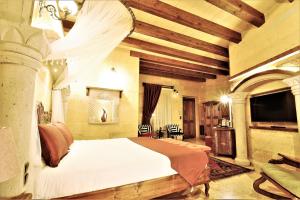a bedroom with a large bed in a room with wooden ceilings at Pegas Cave Suites in Urgup