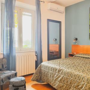 a bedroom with a bed and a mirror and a chair at I Lecci Guesthouse in San Felice Circeo