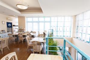 um restaurante com mesas, cadeiras e janelas em Hotel Bell Harmony Ishigaki Island em Ishigaki