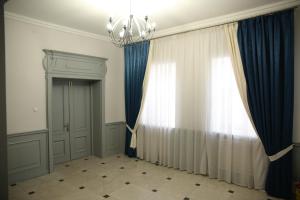 a room with a chandelier and a window at ALCAZAR in Atyraū