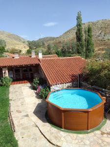 a hot tub in a yard next to a house at CORRAL DEL PRAJONCILLO in Valdecasa