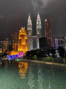 basen z wodą i panoramą miasta w nocy w obiekcie Legasi Kampung Baru by Twenty7 w Kuala Lumpur