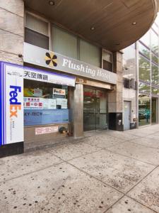 a building with a flush tying house sign on it at Flushing Hotel in Queens