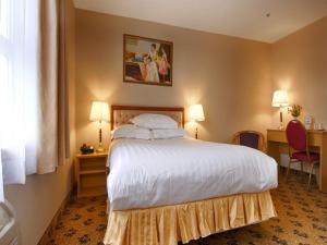 a hotel room with a large bed and a desk at Flushing Hotel in Queens