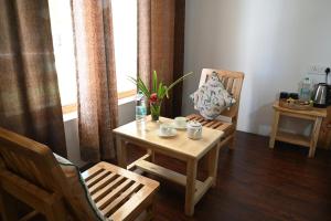 einen Tisch und Stühle in einem Zimmer mit Fenster in der Unterkunft Hunder Haven in Leh