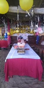 a table with a cake and balloons on it at Shirley's Cottage - Pamilacan Island in Baclayon
