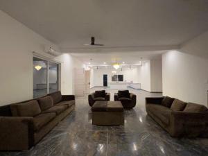 una gran sala de estar con sofás y una mesa. en entire farm and pool for holi party 3bhk with very big hall, en Gurgaon