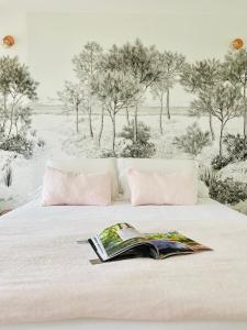 La Cabane du Ferret في ليج-كاب-فيري: غرفة نوم بها سرير مع كتاب عليها