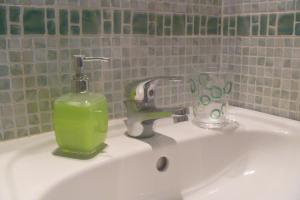 a sink with a soap dispenser and a glass on it at Shiva B&B in Rome
