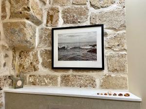 une photo de l'océan dans un cadre photo sur un mur en pierre dans l'établissement Beit Elfarasha, à Acre