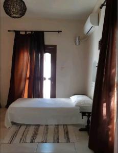 ein Schlafzimmer mit einem großen Bett und einem Fenster in der Unterkunft Orea Kaliva in Sfinárion