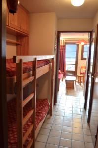 Zimmer mit 2 Etagenbetten und einem Wohnzimmer in der Unterkunft Granges 8 - BEL APPT 4P AU PIED DES PISTES DOMAINE ALPE D'HUEZ in Villard-Reculas