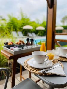 - une table avec une tasse de café et un plateau de nourriture dans l'établissement La Cabane du Ferret, à Lège-Cap-Ferret