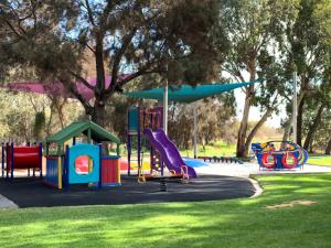 a park with a playground with slides and a slide at Mandurah Caravan and Tourist Park in Mandurah
