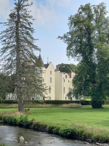 a large castle with trees in front of a river at Holiday Home in Forfar
