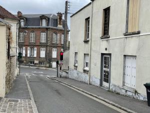 eine leere Stadtstraße mit Gebäuden und einer roten Ampel in der Unterkunft ​Cœur de ville ! Cœur de l'Oise​​ ! Moderne & fonctionnel​ in Clermont