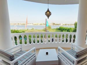 a balcony with two chairs and a view of the ocean at IN LUXOR Nile Apartments in Luxor
