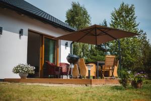 - une terrasse avec des chaises, un parasol et un grill dans l'établissement Kiton House, 