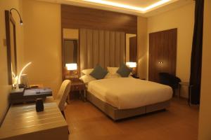 a hotel room with a bed and a desk and lights at Sowirad hotel in Addis Ababa