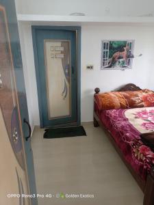 Una habitación con puerta y una cama en una habitación en Kodai sakthi guest house, en Kodaikanal
