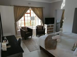 a bedroom with a bed and two chairs and a television at Lauradale Accommodation in Stellenbosch +205 photos
