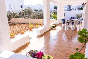 - une terrasse couverte avec une table, des chaises et des fleurs dans l'établissement Villa El Arenal, à Mojácar