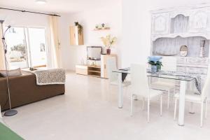 ein Wohnzimmer mit einem Tisch und weißen Stühlen in der Unterkunft Villa El Arenal in Mojácar