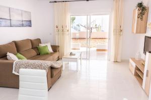 ein Wohnzimmer mit einem Sofa und einem TV in der Unterkunft Villa El Arenal in Mojácar