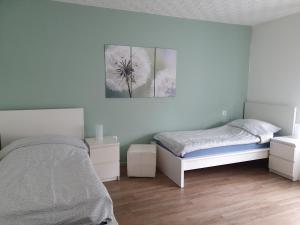 アルンスベルクにあるFewo Beckerのベッドルーム1室(ベッド1台付)が備わります。壁には絵画が飾られています。