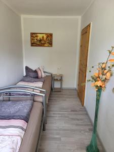 Zimmer mit 2 Betten und einer Vase mit Blumen in der Unterkunft Land,Wald und Wiese in Jürgenstorf