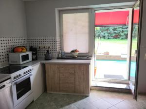 una cucina con piano cottura, forno a microonde e finestra di Land,Wald und Wiese a Jürgenstorf Altre 3 foto