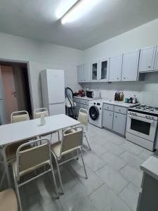 Una cocina con gabinetes blancos y una mesa y sillas. en Mecasa House 2, en Polis Chrysochous