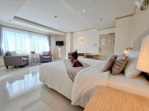 a bedroom with a large bed and a living room at Thipurai City Hotel in Hua Hin