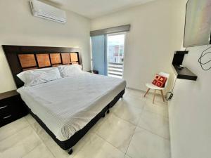 - une chambre avec un grand lit et une chaise dans l'établissement Kentia 27, Residencial privado, accesible y cómodo, à Culiacán