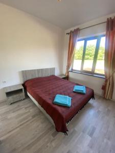 1 dormitorio con 1 cama con 2 toallas azules en Guest house Simiram en Cholpon-Ata