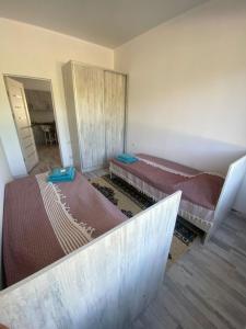 Dos camas están en una habitación con tres letras. en Guest house Simiram en Cholpon-Ata
