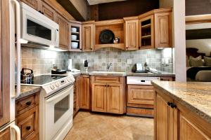 a kitchen with wooden cabinets and white appliances at Luxury Three Bedroom Suite with Mountain Views and Hot Tub apartment hotel in Park City