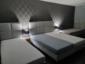 dwa łóżka w małym pokoju z dwoma lampami w obiekcie Villa Akacjowa w mieście Turbia +29 zdjęć